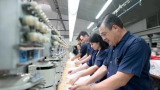 People operating machines at an embroidery factory